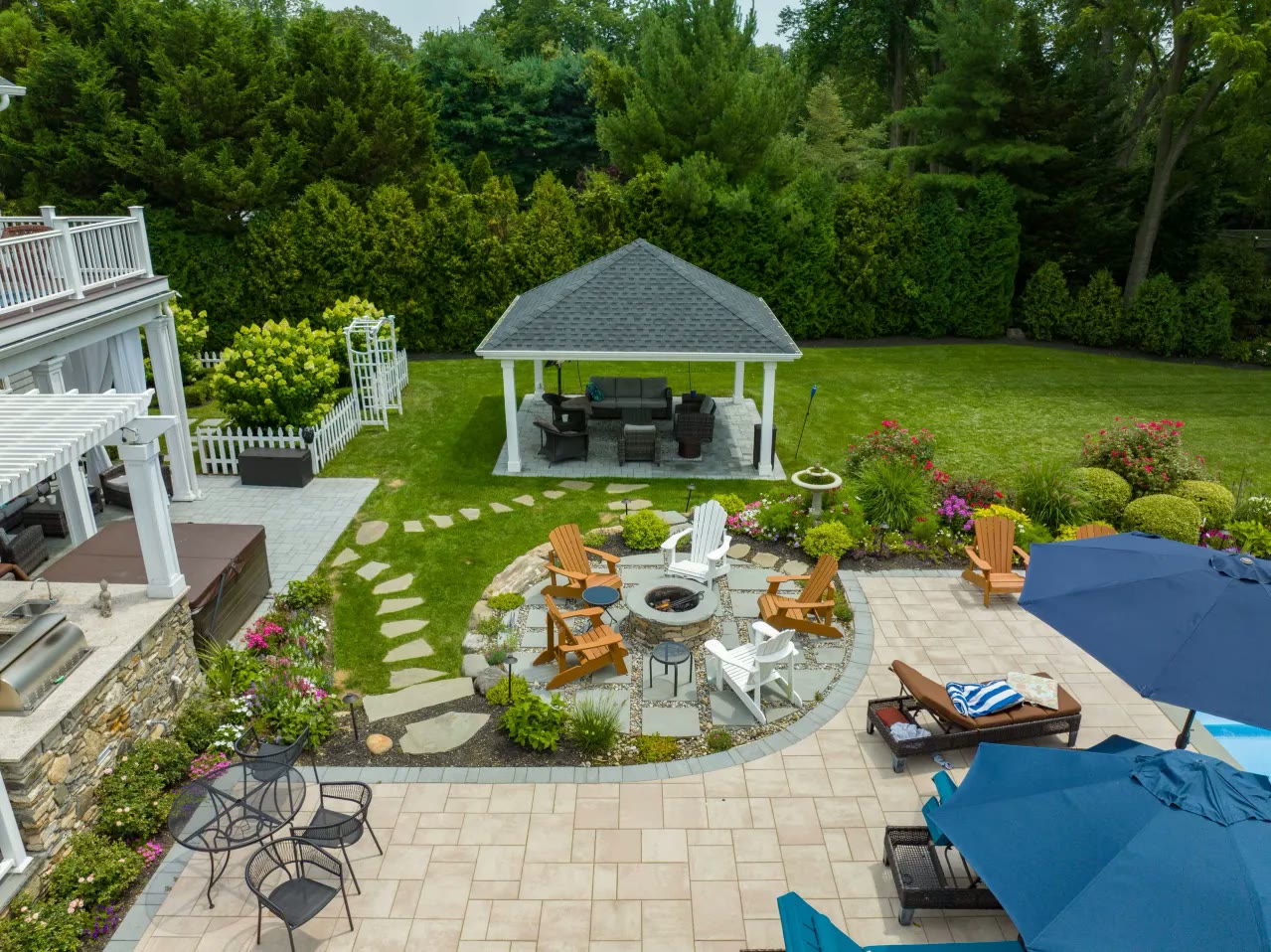 Aerial view of a backyard with gazebo, fire pit circle, stepping-stone path and outdoor kitchen