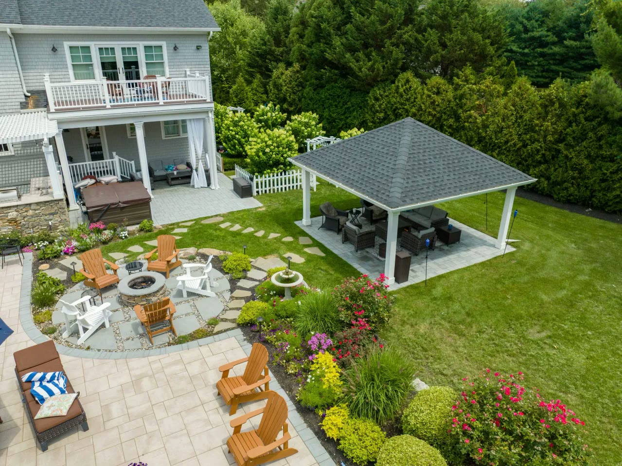 Aerial view of a garden with pavilion, fire pit circle, fountain and flowering beds