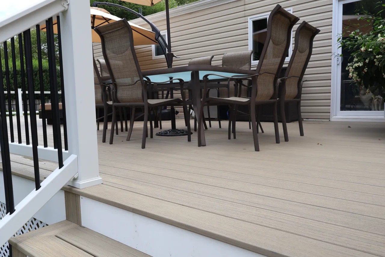 Composite deck with an outdoor kitchen, granite bar counter and covered grill