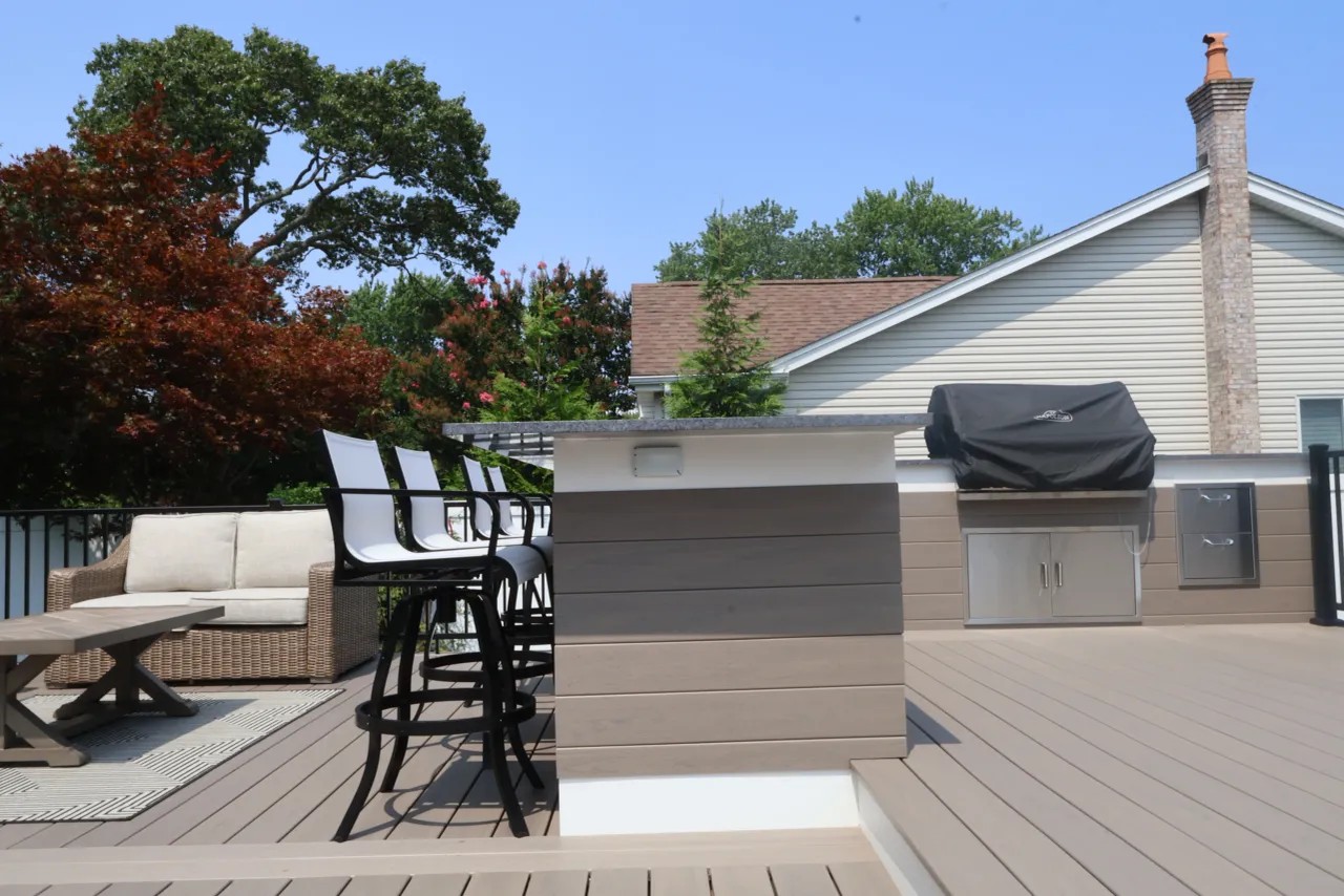 Raised composite deck with black aluminum railing overlooking the lawn