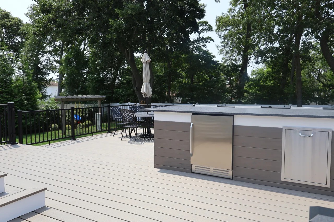 White deck rail with black balusters above a hydrangea hedge