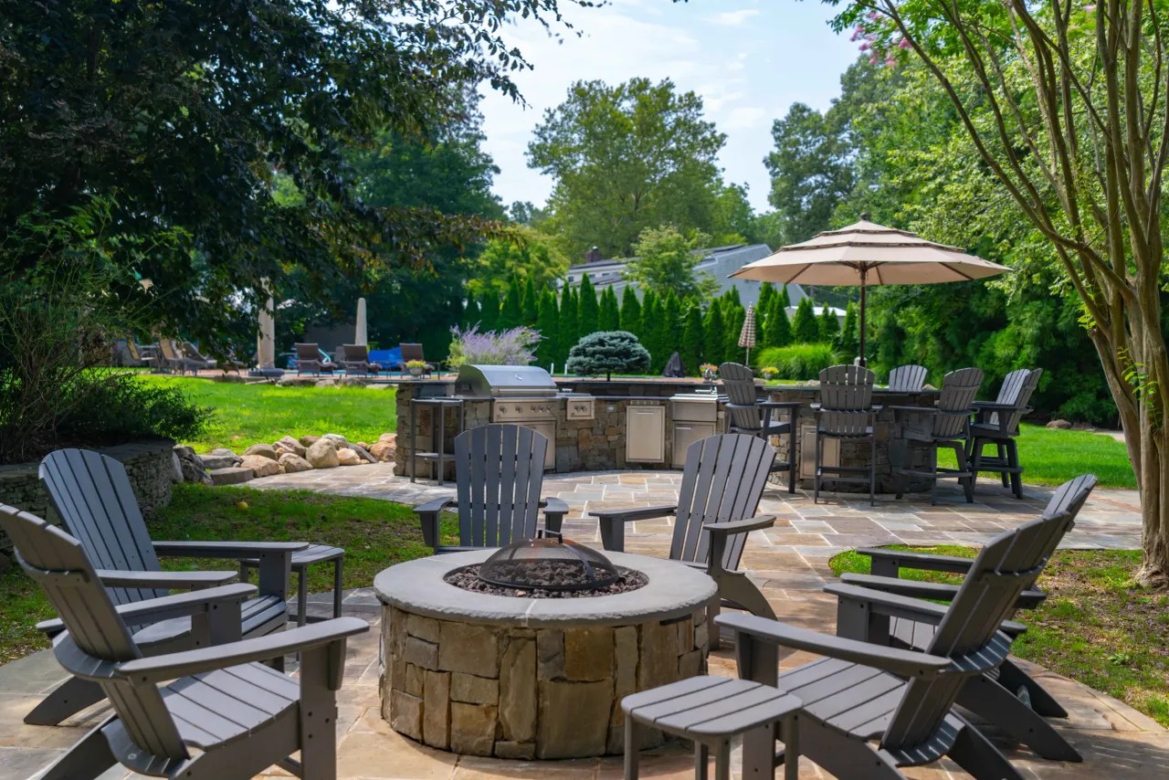 Round stone fire pit with Adirondack chairs