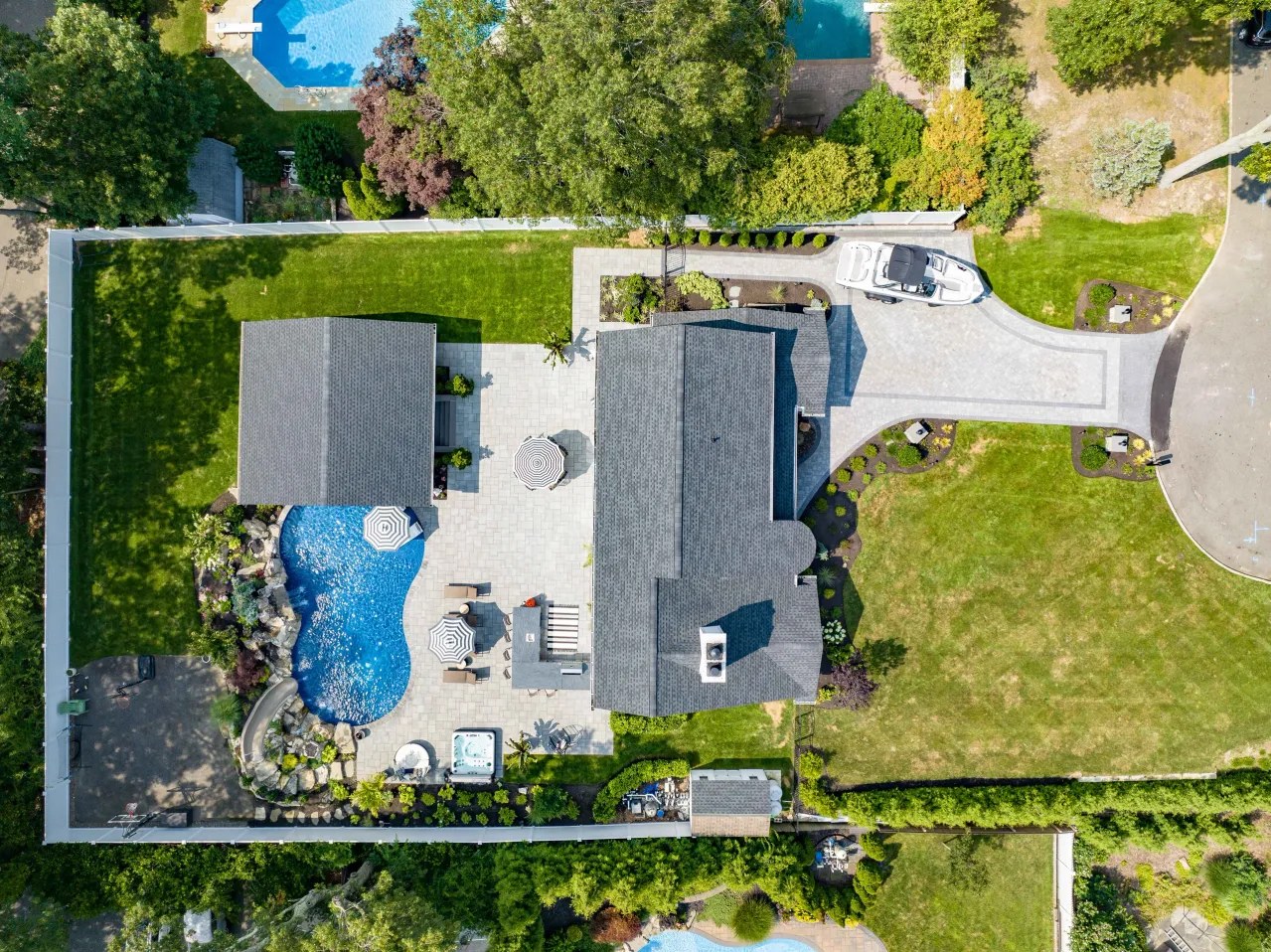 Aerial view of a completed backyard with pool, patio and pavilion