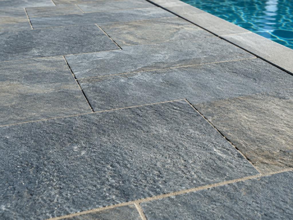 Close-up of blue-gray thermal-finish bluestone slabs on a pool patio