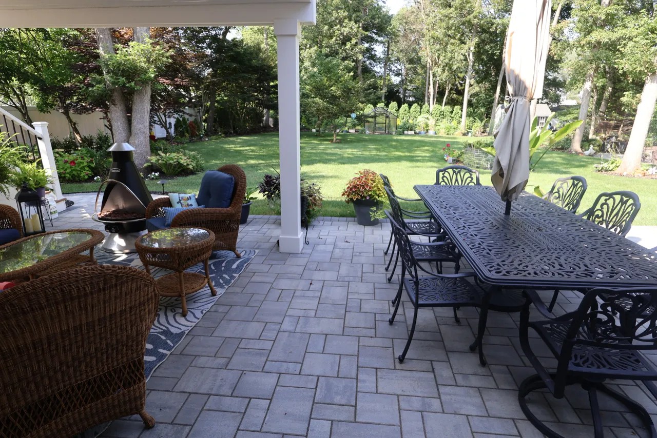 Covered patio with cast-iron dining table under a white pergola