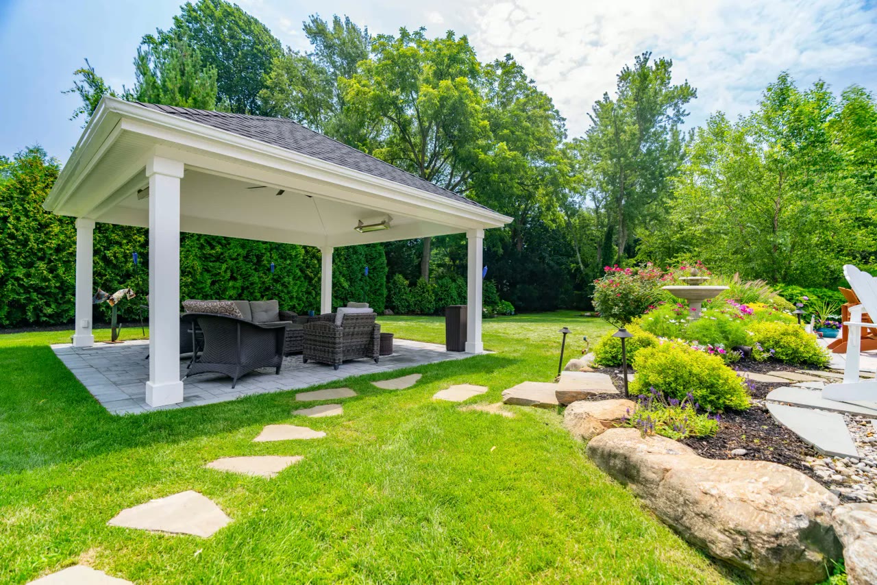 Stepping-stone path across the lawn to a white pavilion with outdoor seating