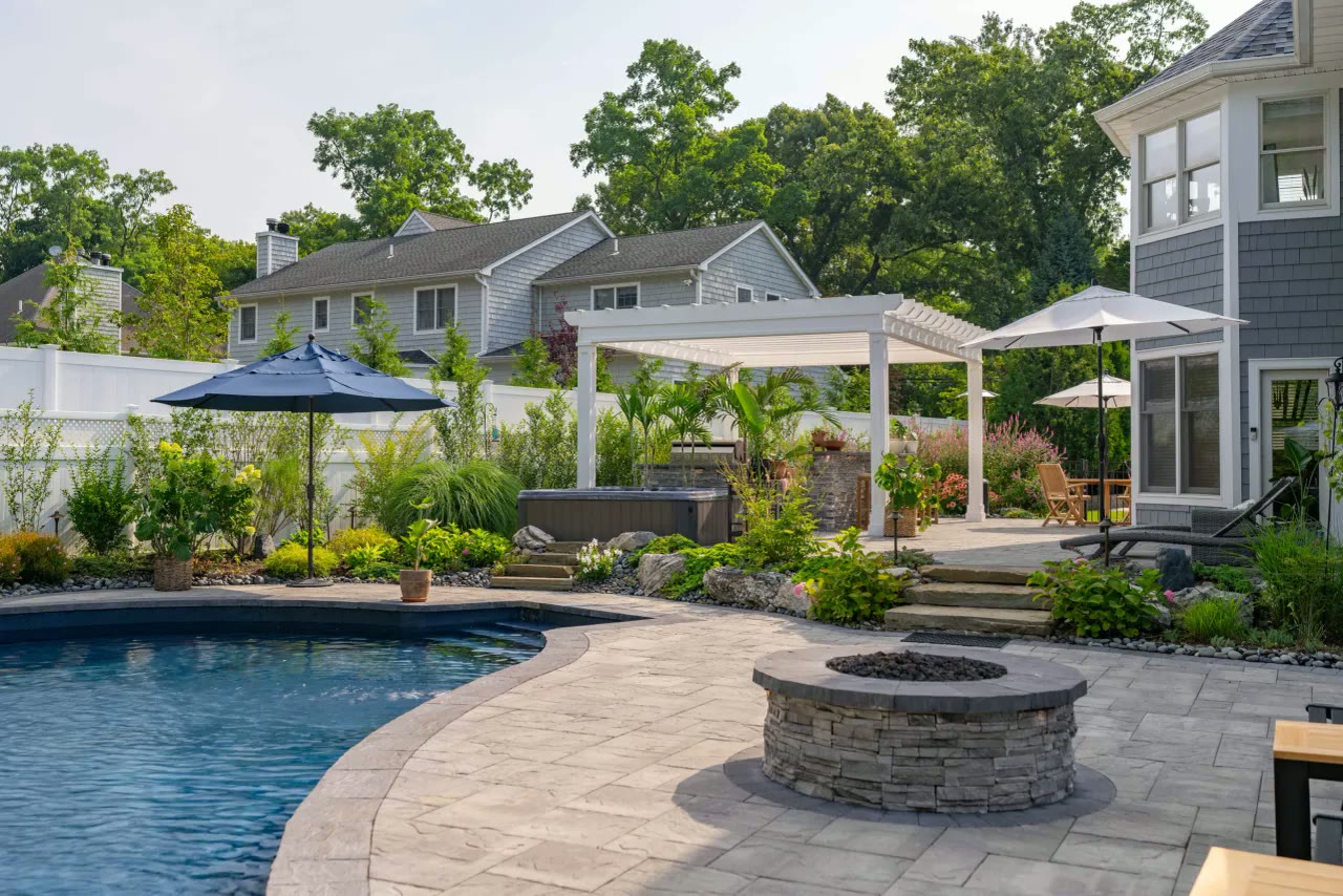 Pool with curved paver patio, stone fire pit, hot tub and white pergola