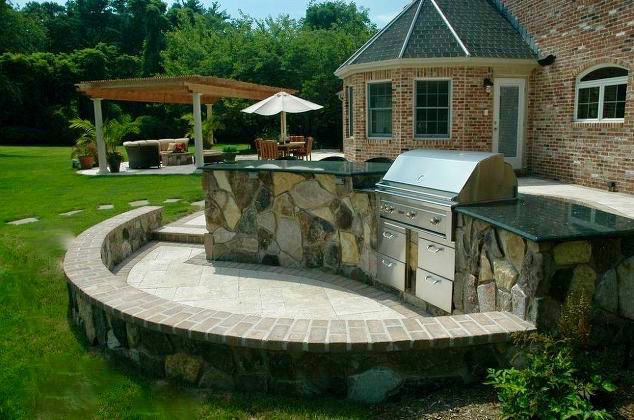 Travertine Patio/Outdoor Kitchen: Close to the outdoor living room and dining area is the client’s bar/barbecue. With a natural stone veneer, an semi-circular seat wall with the same veneer offers extra seating when entertaining. 